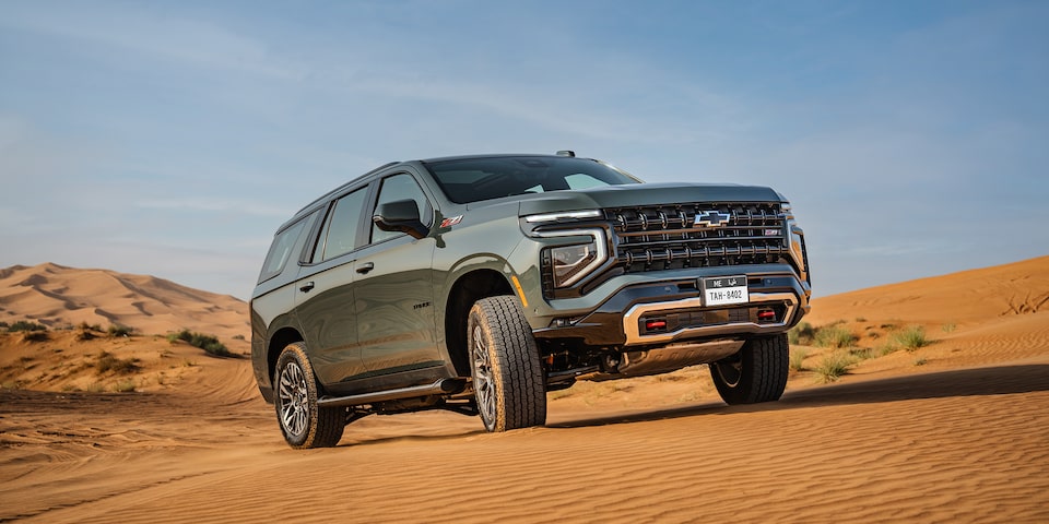 Front Three-quarters View of the 2025 Chevrolet Tahoe SUV Driving on a Sand Path