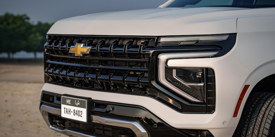 Front Three-quarters View of the 2025 Chevrolet Tahoe SUV parked on sand surface surrounded by trees