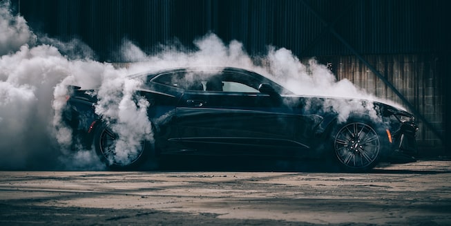 Black Chevy Camaro performing a burnout