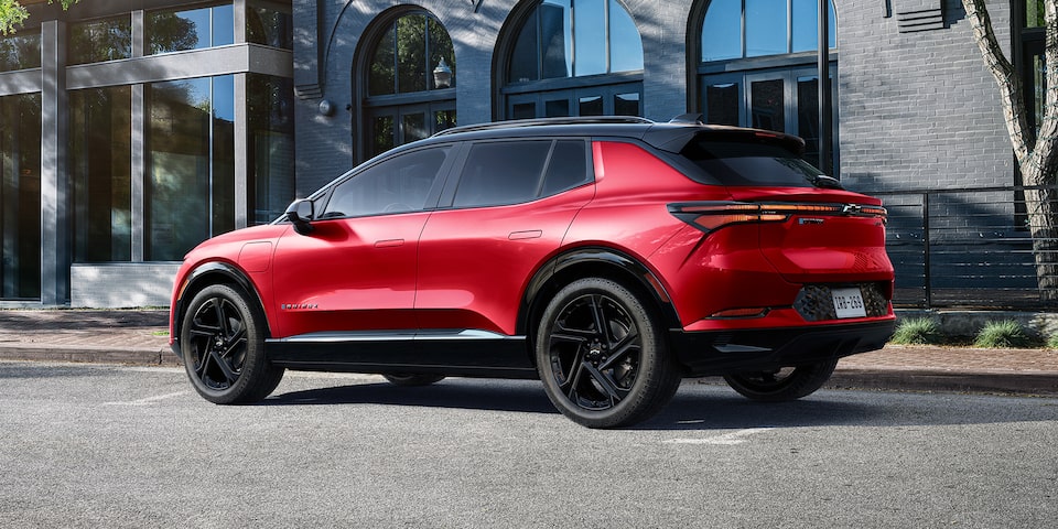 Side View of a Red 2025 Equinox EV Next to a Building